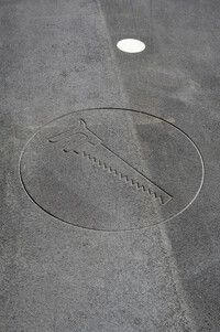 Imprint in asphalt illustrates a saw